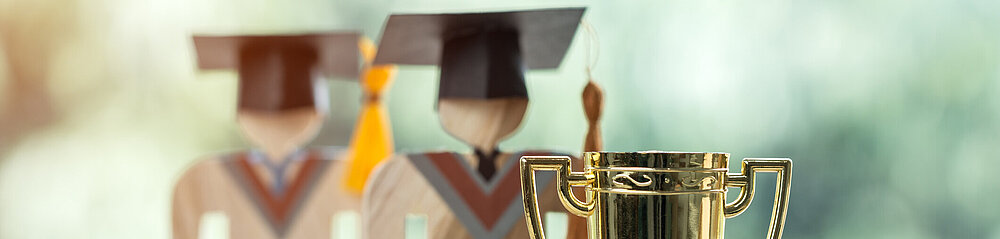 ©istock Pokal und Doktorabsolventen als Figuren