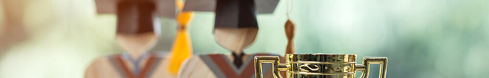 ©istock Pokal und Doktorabsolventen als Figuren