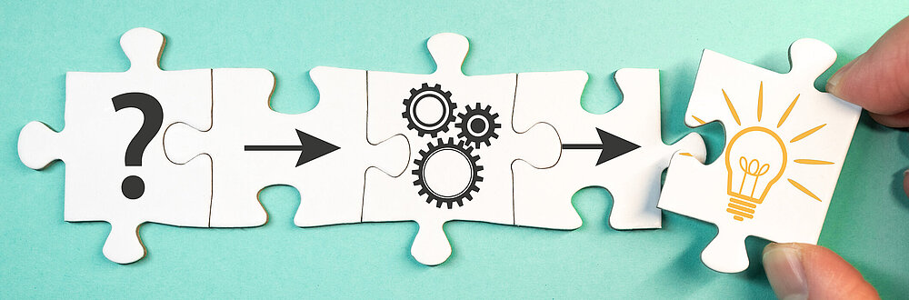 ©iStock\marchmeena29 Auf dem Bild sind Puzzelteile zu sehen und eine Hand, die eines der Puzzelteile aus dem Bild zieht.