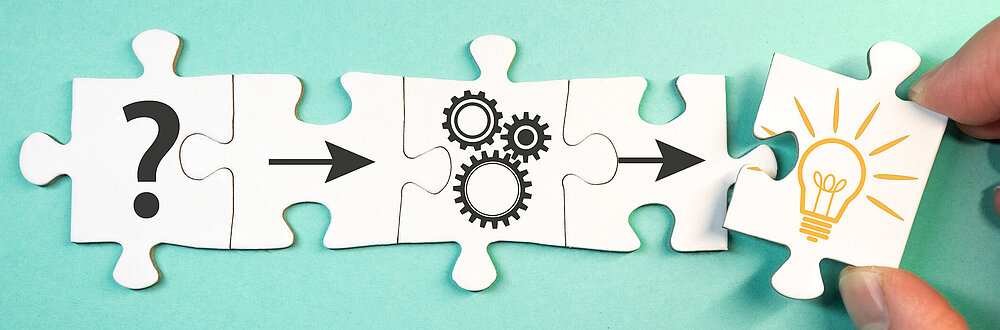 ©iStock\marchmeena29 Auf dem Bild sind Puzzelteile zu sehen und eine Hand, die eines der Puzzelteile aus dem Bild zieht.